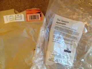 Ripped brown envelope with Royal Mail packaging saying damaged
