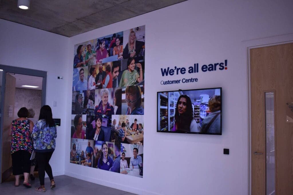 Tesco room pictures on wall of people and "we're all ears"