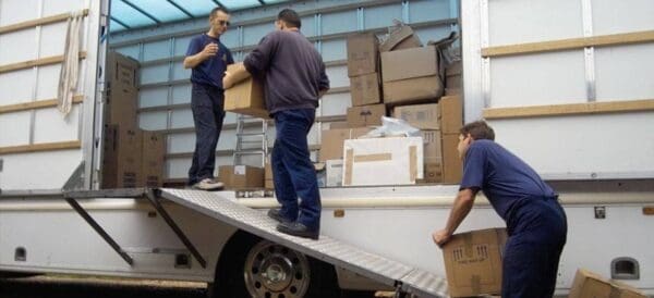 Two men moving boxes out of van