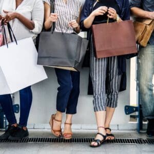people carrying shopping bags from shoulders down