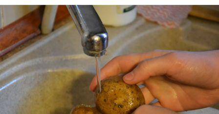 washing potatoes under running tap