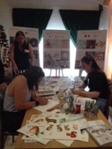 Two women drawing at table