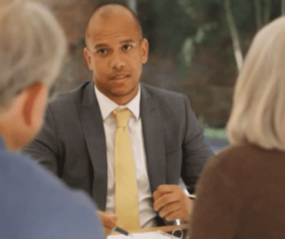man talking across table to couple