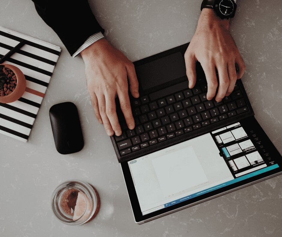 two hand on laptop on desk