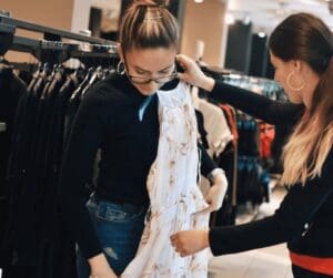 Woman being served by woman showing dress