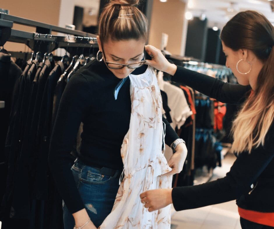 Woman being served by woman showing dress