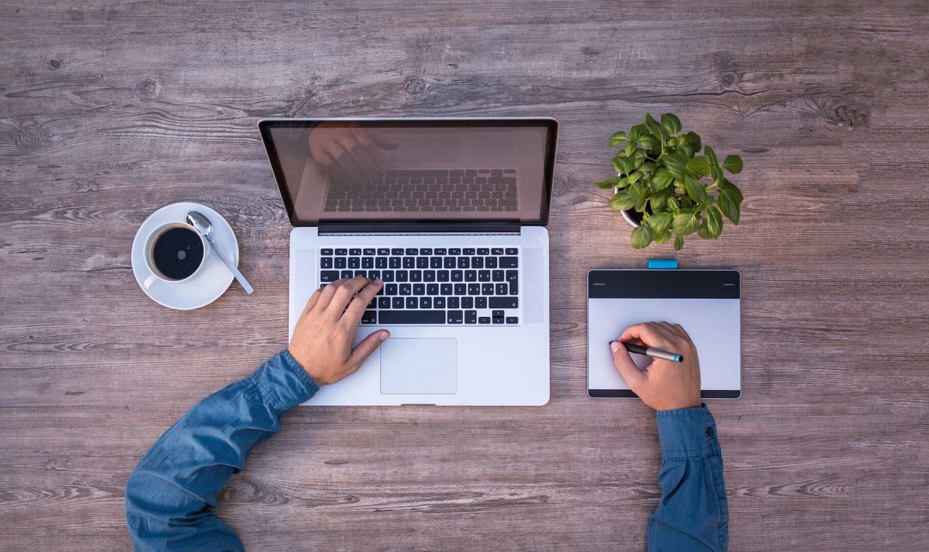 laptop hand typing other writing on pad