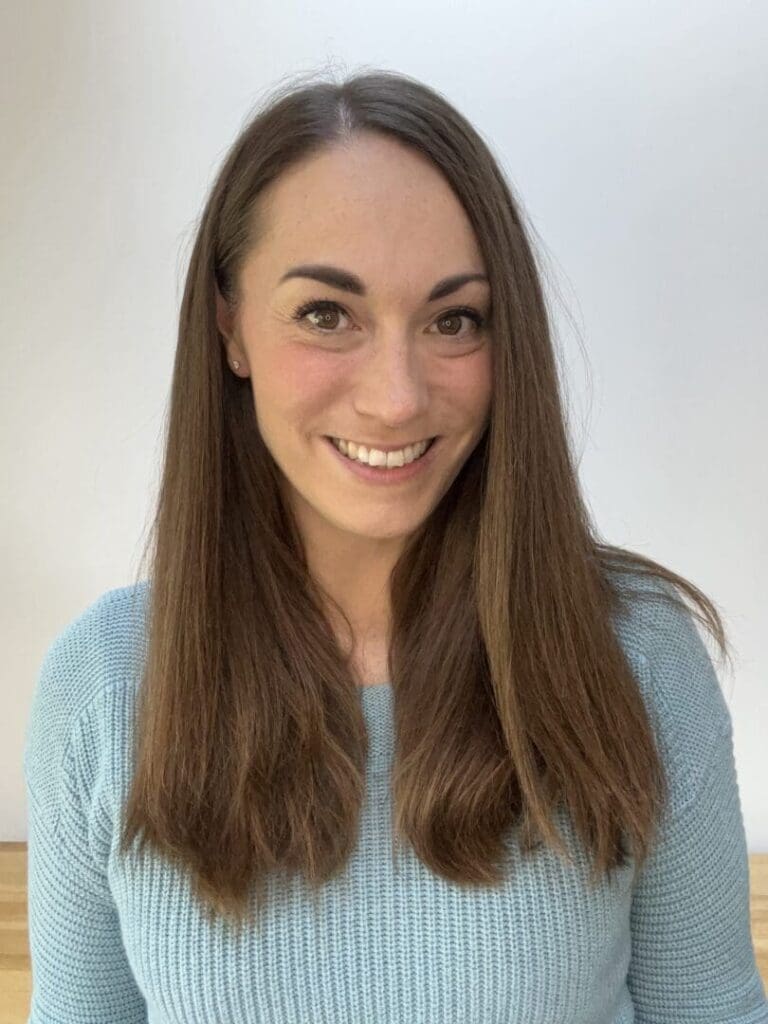 Kate Hall head shot young female long dark hair light green top