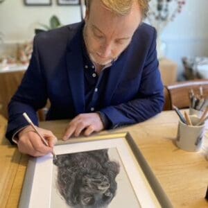 Rob at desk drawing a dog