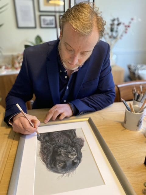 Rob at desk drawing a dog