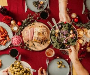 Table full of food hand passing a bowl