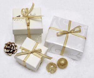 3 boxes wrapped in silver paper with gold ribbon