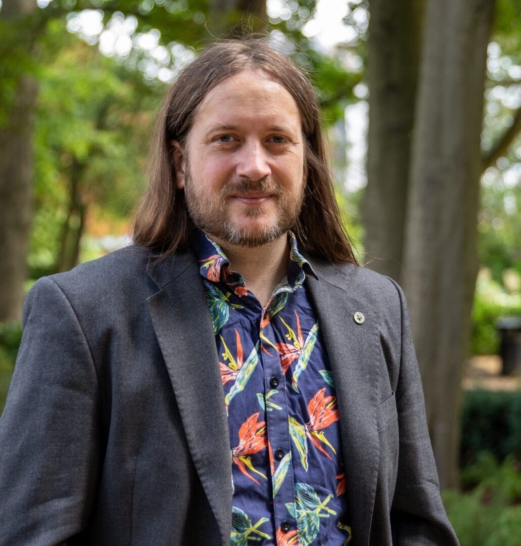 Long hair man in suit bright patterned shirt