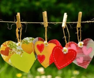 4 home made hearts cards and material pegged on line outside