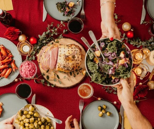 Plates on table full of food one hand passing plate to another