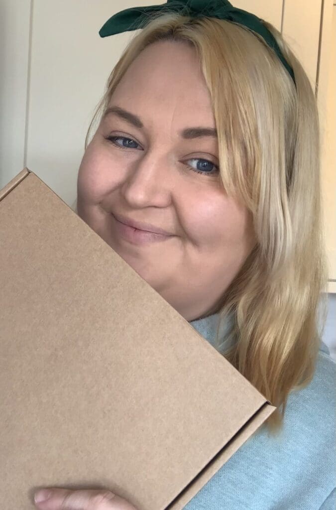 Jodie Clough head and shoulders mid length blond hair holding a box