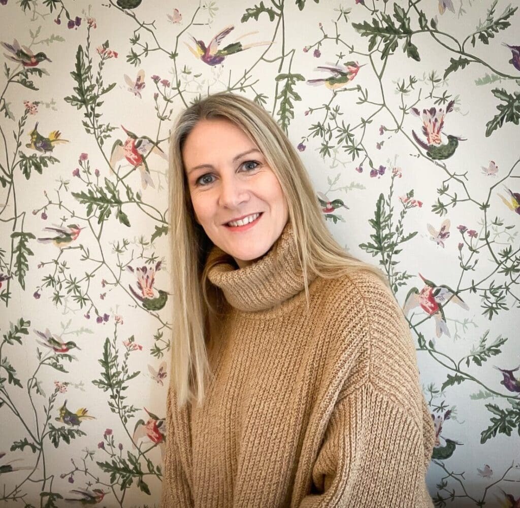 White woman long blond hair polar neck beige jumper background wallpaper leaves and flowers