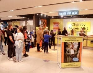 Charity supermarket sign. shop floor people standing