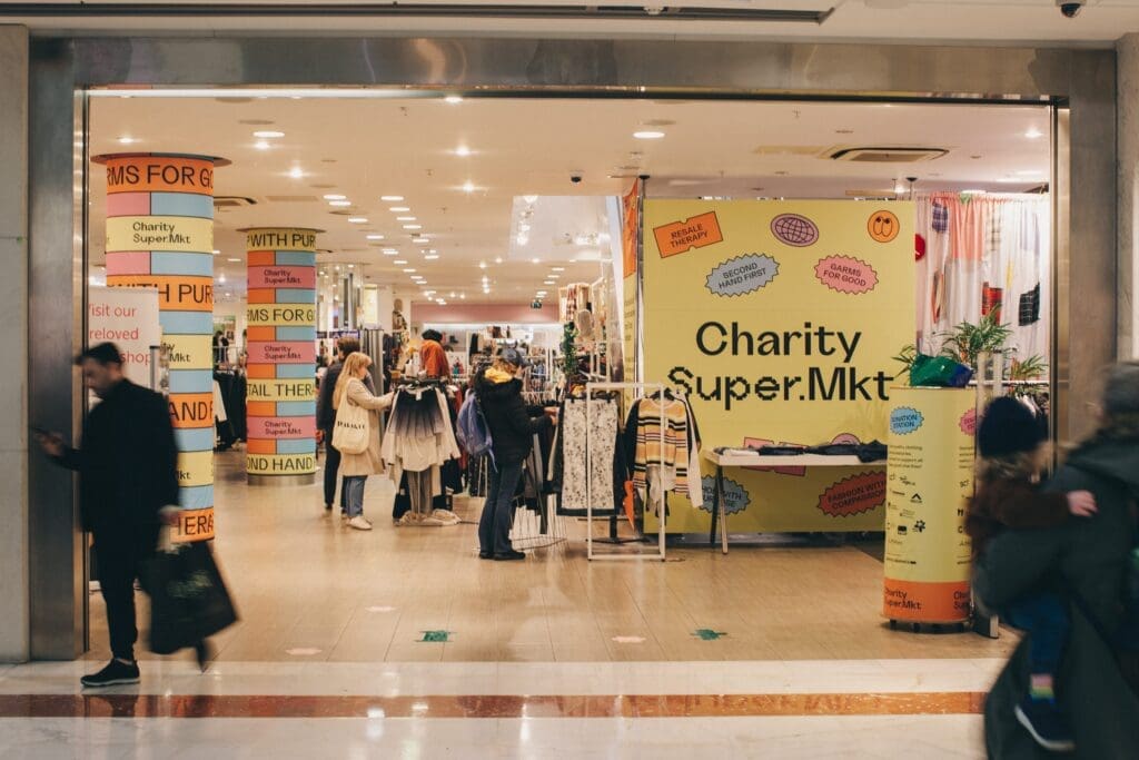 Charity supermarket sign. shop floor people standing around