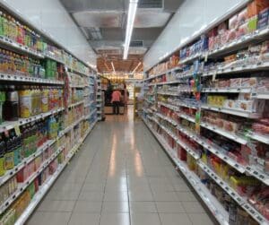 long supermarket aisles products on the shelves person right at the end