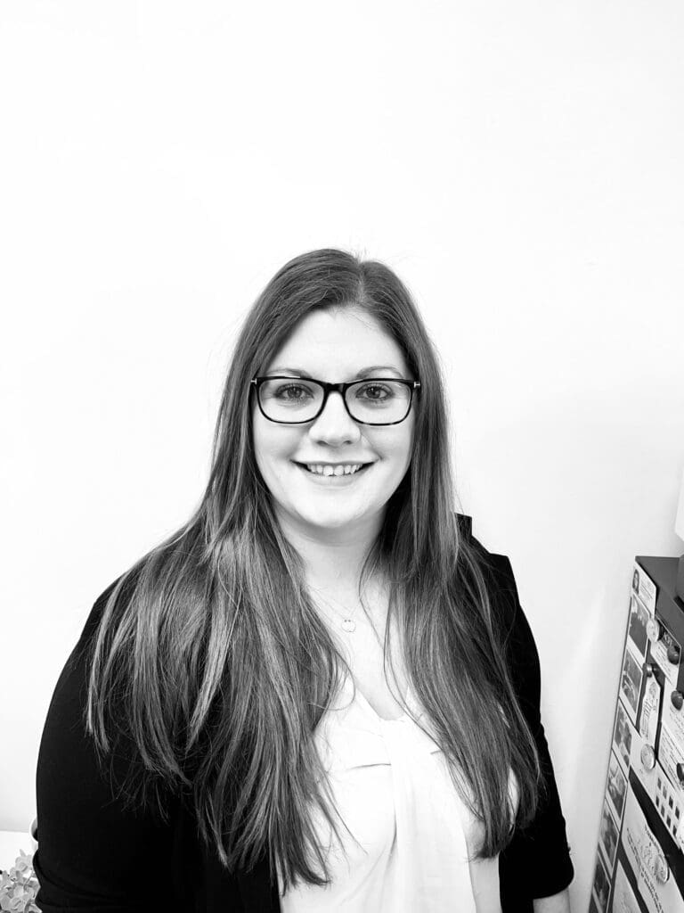 Black and white photo white woman in 30s long straight hair wearing glasses