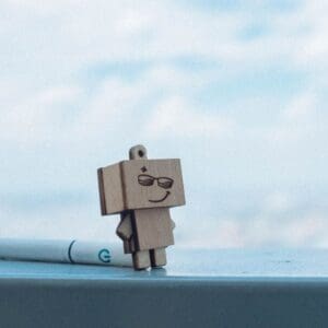 Amazon box smile on box to look like person- box arms and legs in front of cloudy sky