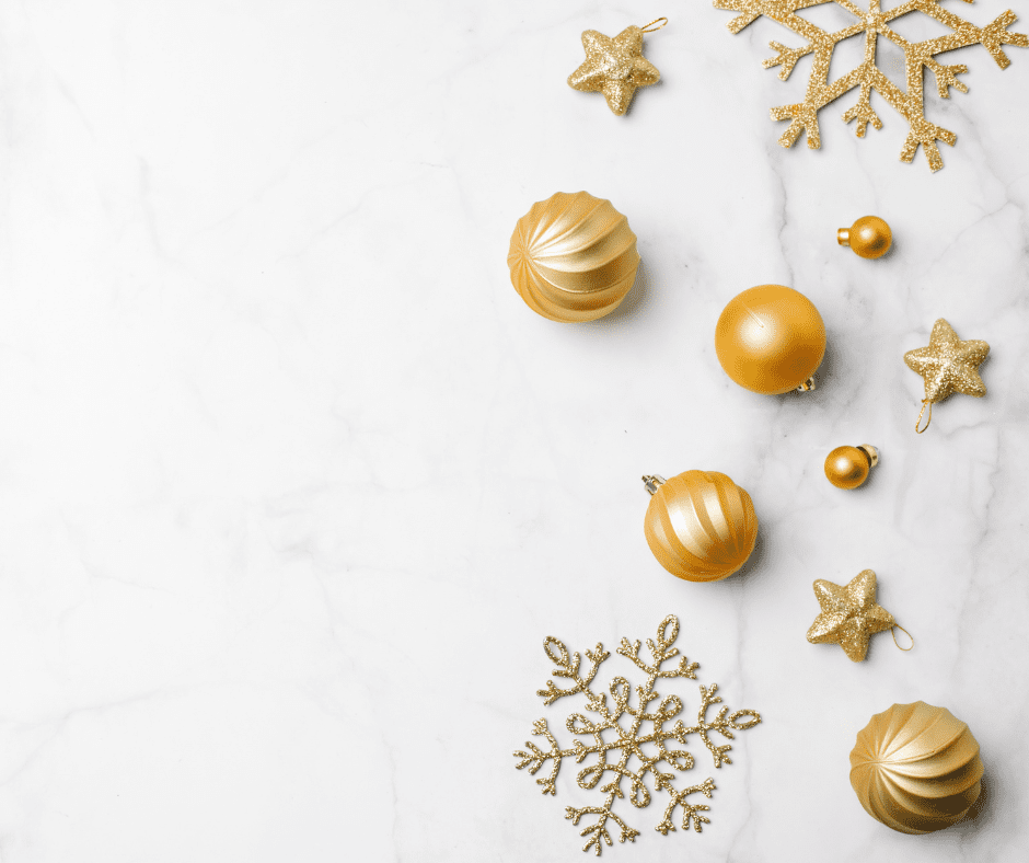 White background 4 gold baubles and 2 smaller ones and a few gold snowflakes
