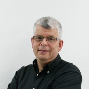White man short grey hair, black shirt, head and shoulders