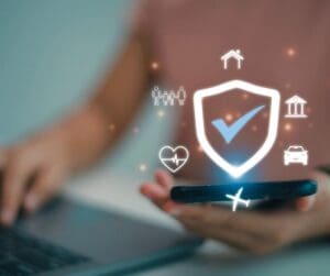 Blurred woman top half pink top one hand on laptop one hand holding tablet graphic white shield white aeroplane, house around