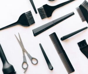 mixture of silver colour scissors and black combs and colour dye brushes