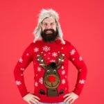white man in 40s dark beard smiling blond wig xmas jumper