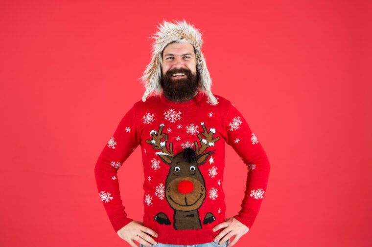 white man in 40s dark beard smiling blond wig xmas jumper