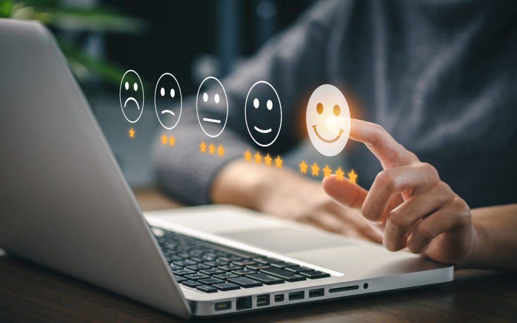 laptop open hands above happy to sad faces in air
