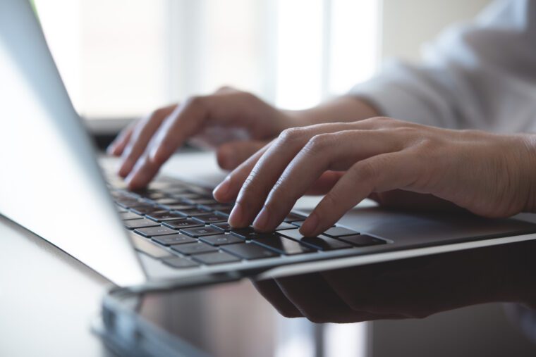 Close up, woman hands typing on laptop computer keyboard, surfing the internet on office table, online, working,