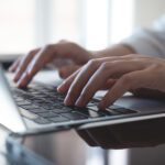 Close up, woman hands typing on laptop computer keyboard, surfing the internet on office table, online, working,