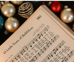 Page of music for Little Town of Bethlehem baubles around the book