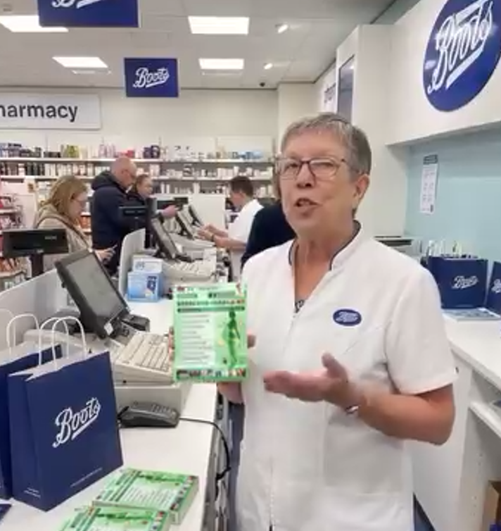 A deepfake depicting a woman with noticeably distorted and unrealistic hands. The Boots logo on her uniform undergoes subtle changes over the course of the video.