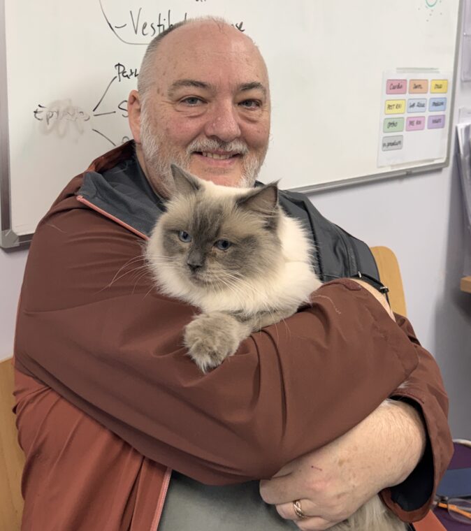 Nic Maber holding his cat at the vets where he was overcharged.