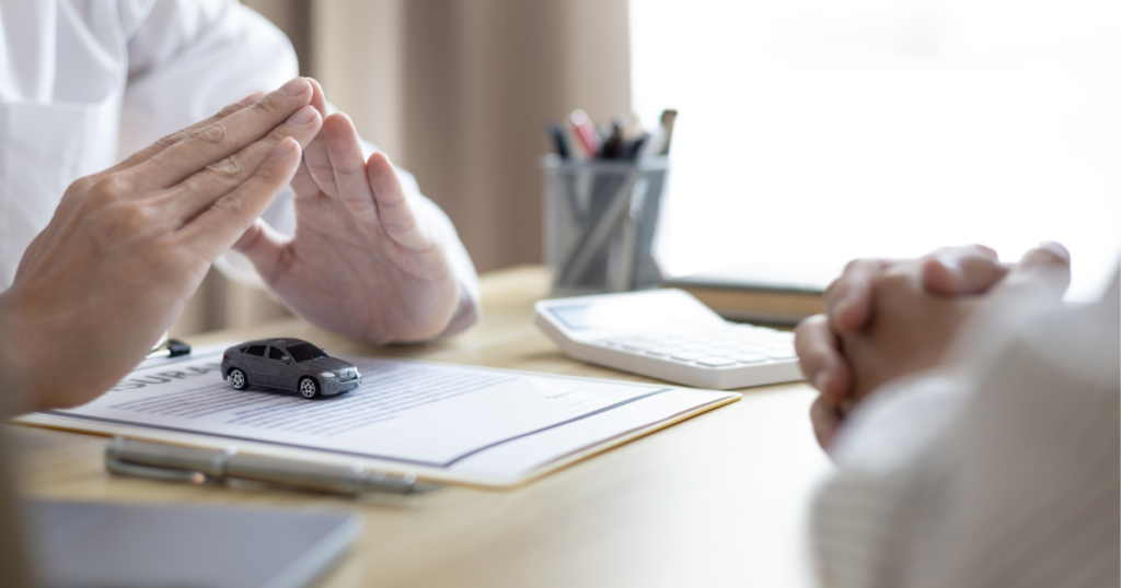 either side of table showing two arms and hand of people one over a document pot of pens to the side